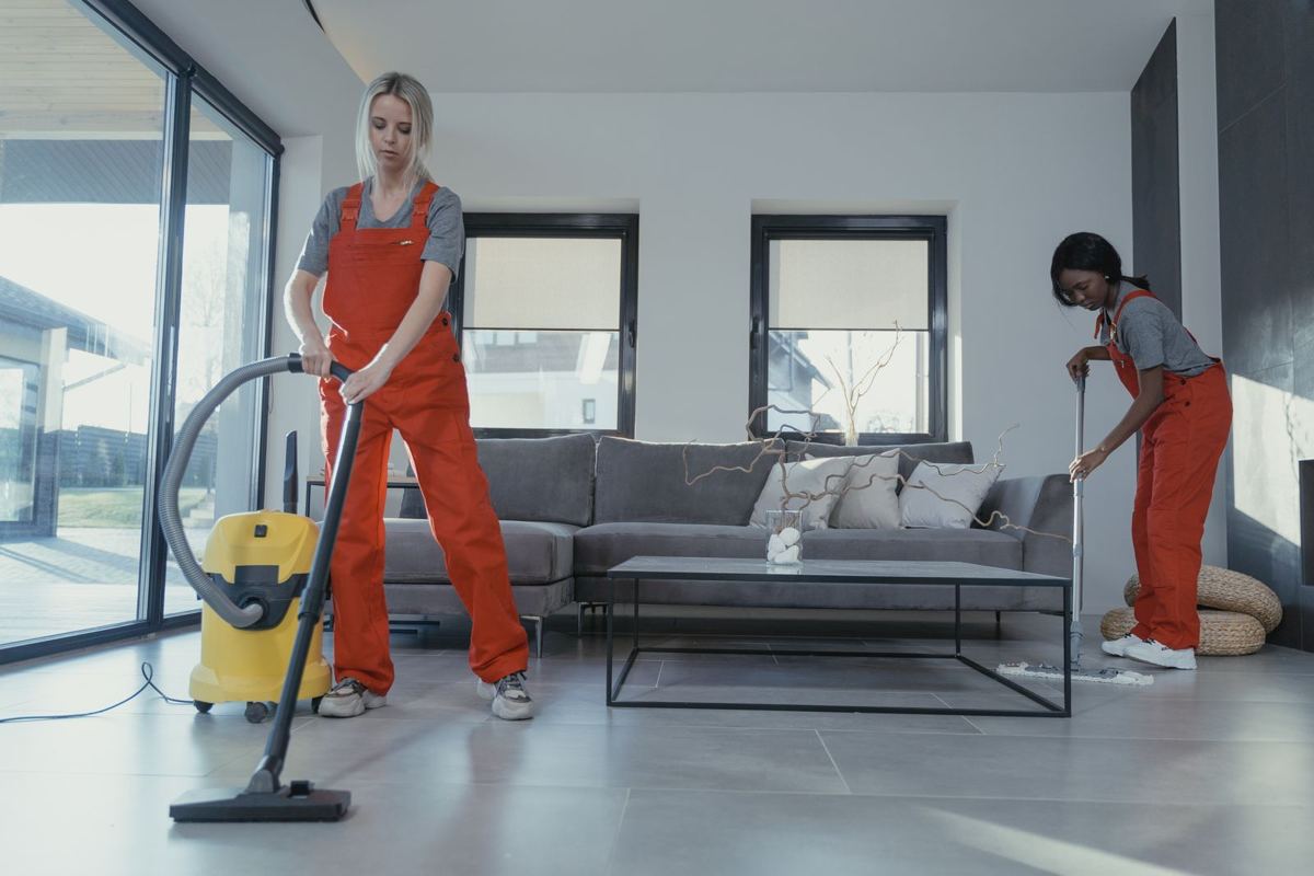 Cleaning crew vacuuming and sweeping a home living room