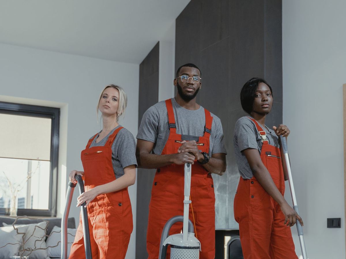 Cleaning team standing with vacuum and cleaning equipment in a home